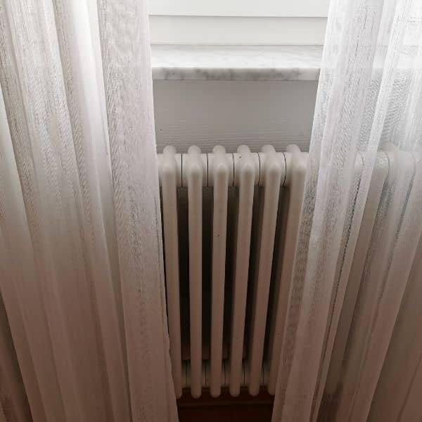long curtains over a column radiator