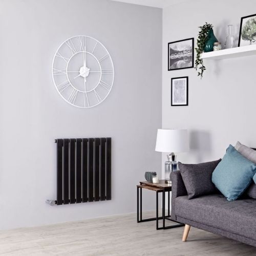 milano alpha black electric wall mounted heater in a grey living room