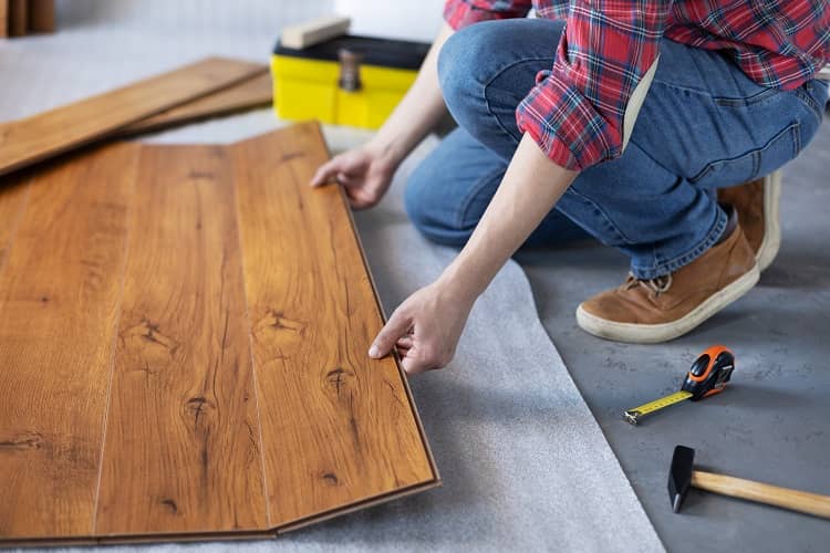 a man installing flooring to make his home more energy efficient