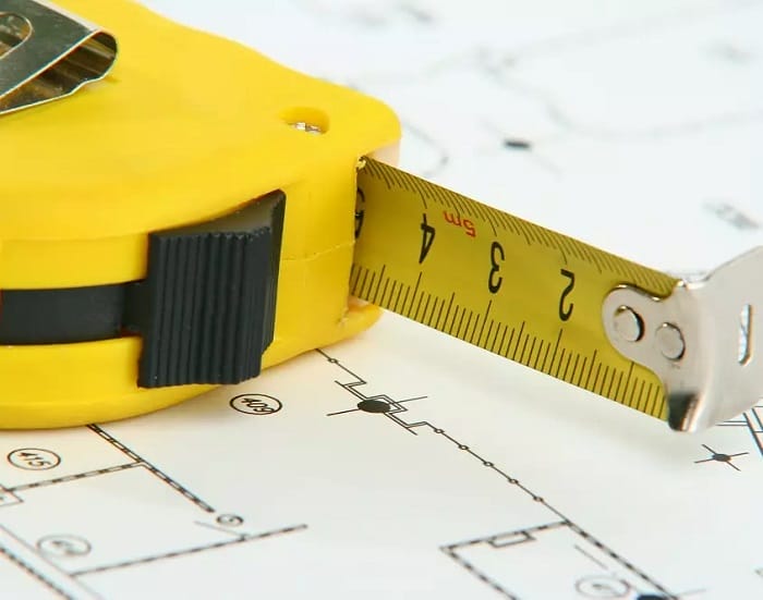 Yellow tape measure Close up of yellow tape measure on blueprint