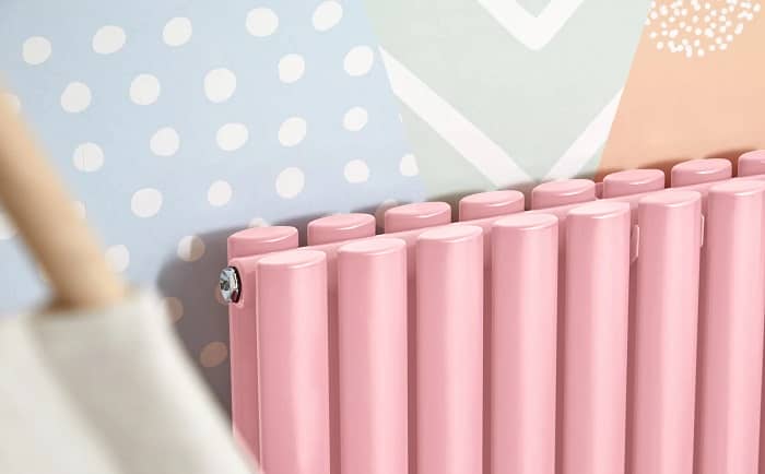 Milano Aruba pink horizontal radiator Close up zoomed in shot of Milano Aruba Pink Horizontal Designer Radiator on colourful patterned wall
