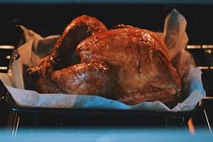 A turkey in an oven A turkey roasting in an oven