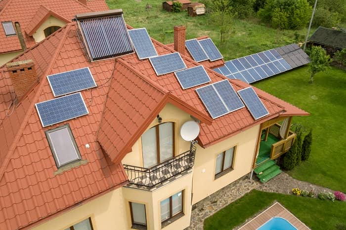 Lower part of gold cast iron radiator Aerial view of large house with multiple solar panels
