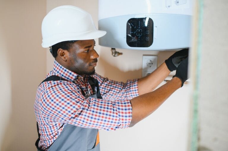 Professional in hard hat with shirt and overalls repairing a central heating system