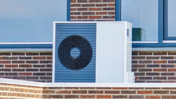 Modern air source heat pump HVAC system Air source heat pump HVAC unit installed outside a modern house with red brick wall