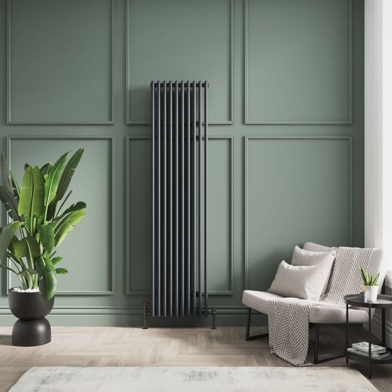 Milano Esme black vertical aluminium traditional radiator on green wall nearby white chair and houseplant in black vase
