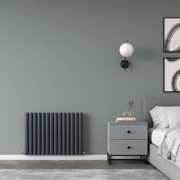 Milano Aruba Ayre aluminium anthracite horizontal designer radiator on green wall in modern bedroom nearby bedside drawer cabinet beneath a lamp and bed beneath artwork