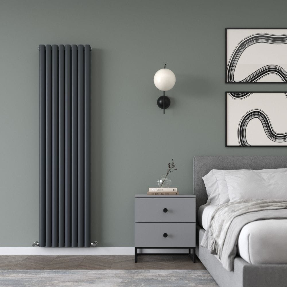 Milano Aruba Ayre anthracite aluminium vertical designer radiator on green wall nearby grey bedside cabinet underneath light fitting next to bed beneath framed artwork