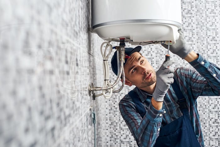 Handyman setting up electric immersion heater boiler system Handyman setting up electric immersion heater boiler system