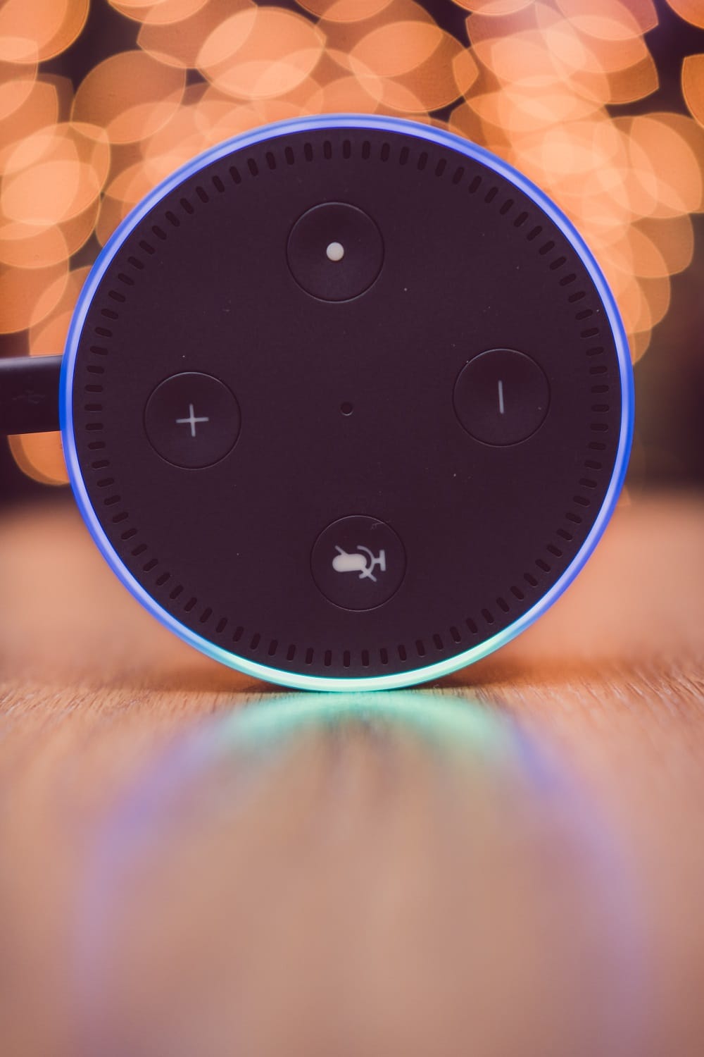 Amazon Alexa Echo Dot device on wooden table