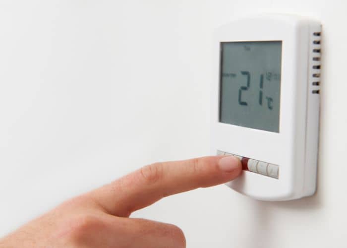 hand turning the heating off