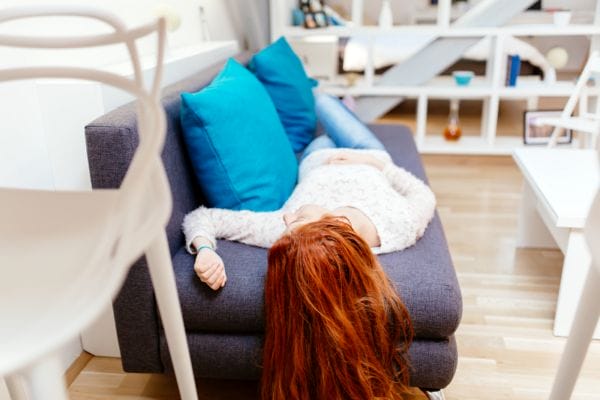 red-haired woman led on a sofa