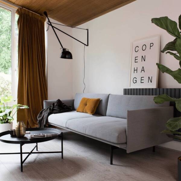 Milano Alpha radiator behind a grey sofa