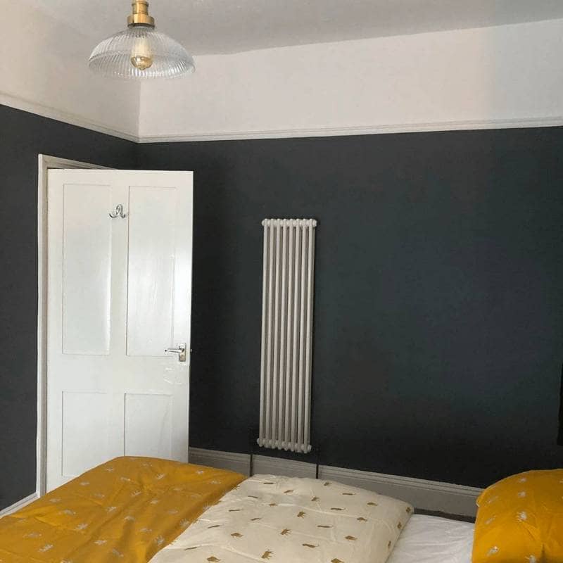 Milano Windsor white vertical radiator on a navy wall