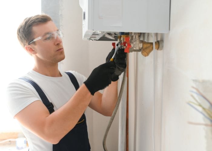 plumber working on a boiler service plumber working on a boiler service
