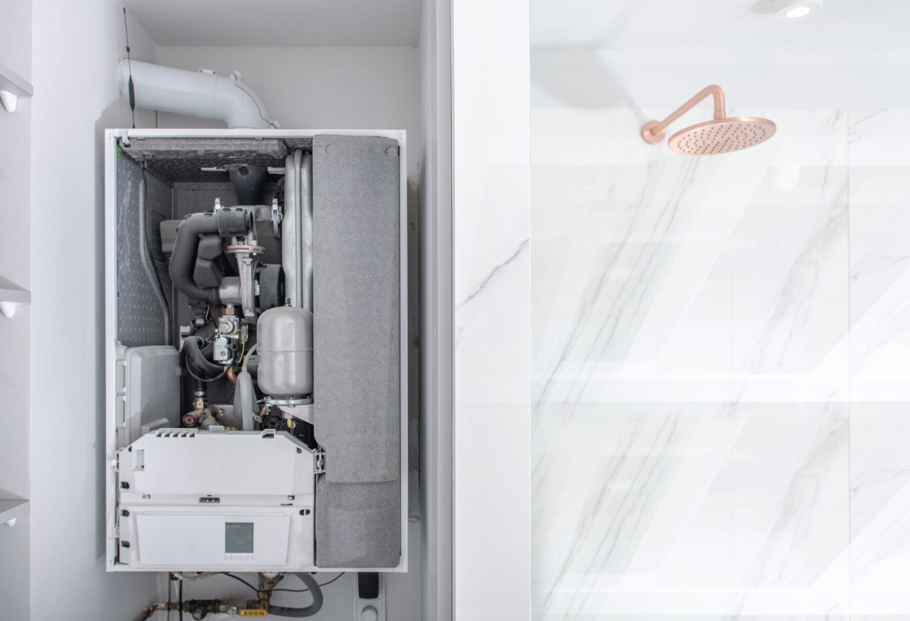 Open broken modern boiler next to shower in clean bathroom interior Open broken modern boiler next to shower in clean bathroom interior