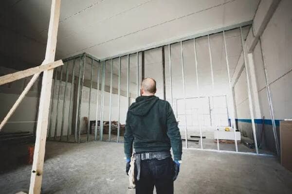 builder assessing a plasterboard room