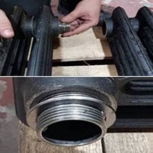 Step 2 hand screwing joining nipples onto cast iron radiator