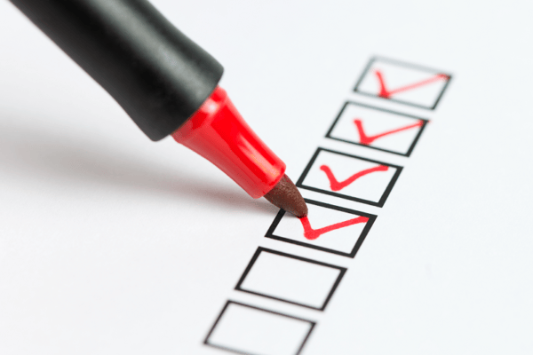 a red pen checking a box on a checklist