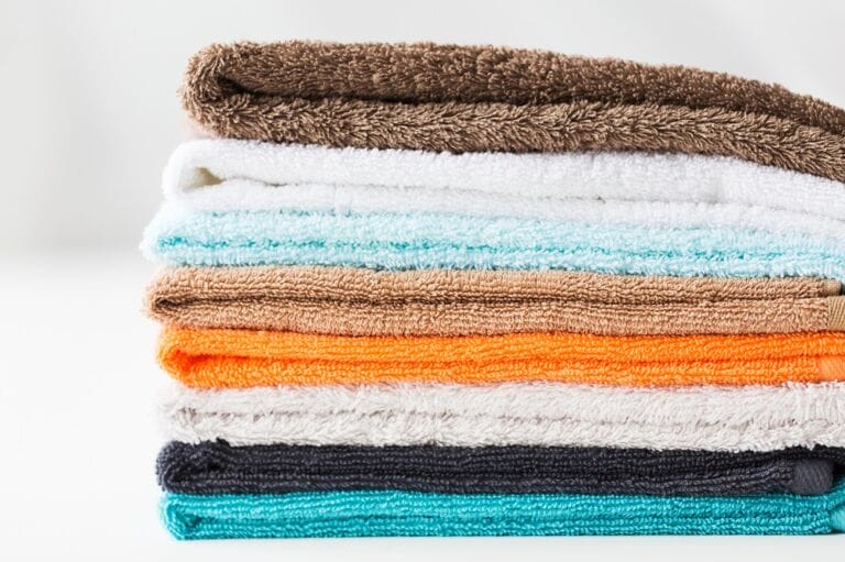 Close up image of stack of bath towels in different colours