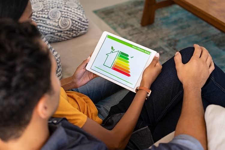 A couple checking on digital tablet housing energy efficiency rate.