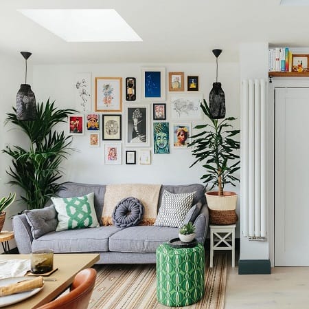 Slim vertical white designer radiator in busy living room setting Slim vertical white designer radiator in busy living room setting