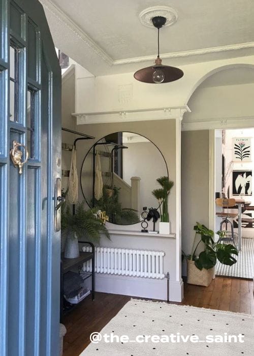 low level radiator with a wooden shelf above with vases and plants