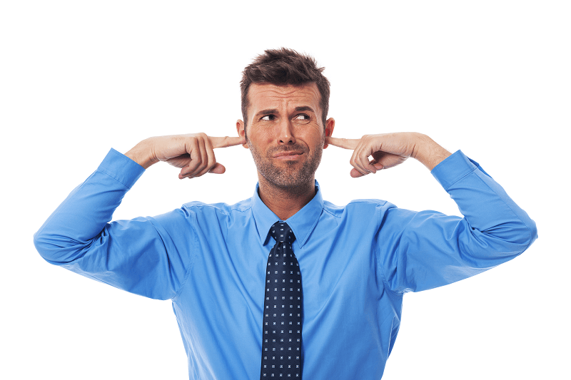 man in blue shirt with fingers in his ears