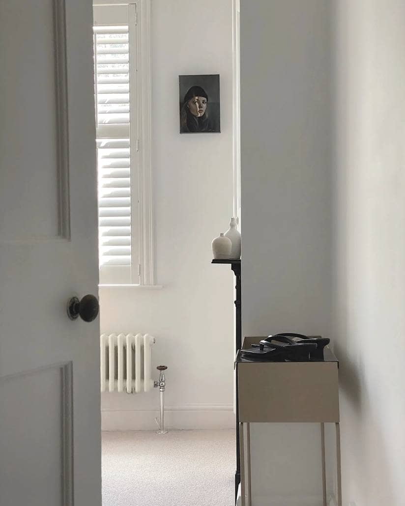 the corner of a white column radiator seen through an open door