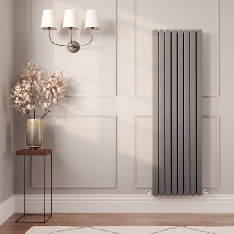 Milano Capri anthracite flat panel designer radiator on light wall nearby gold vase with artificial plant beneath triple light fitting