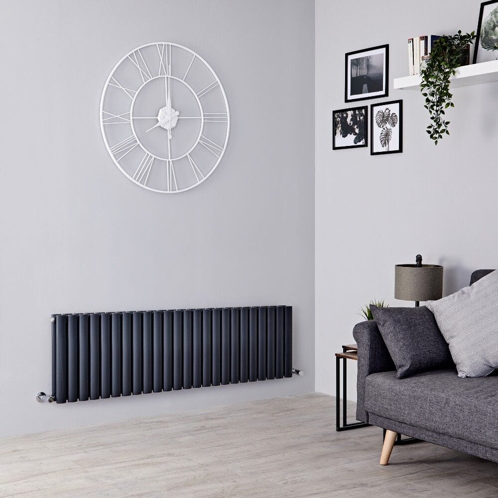 Milano anthracite horizontal designer radiator on white wall beneath clock near to small table and settee