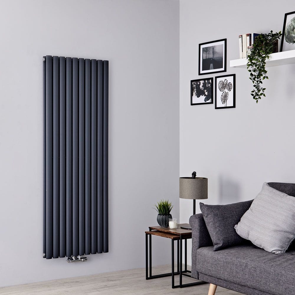 Milano Aruba Flow anthracite vertical middle connection radiator on white wall nearby table with lamp and grey settee
