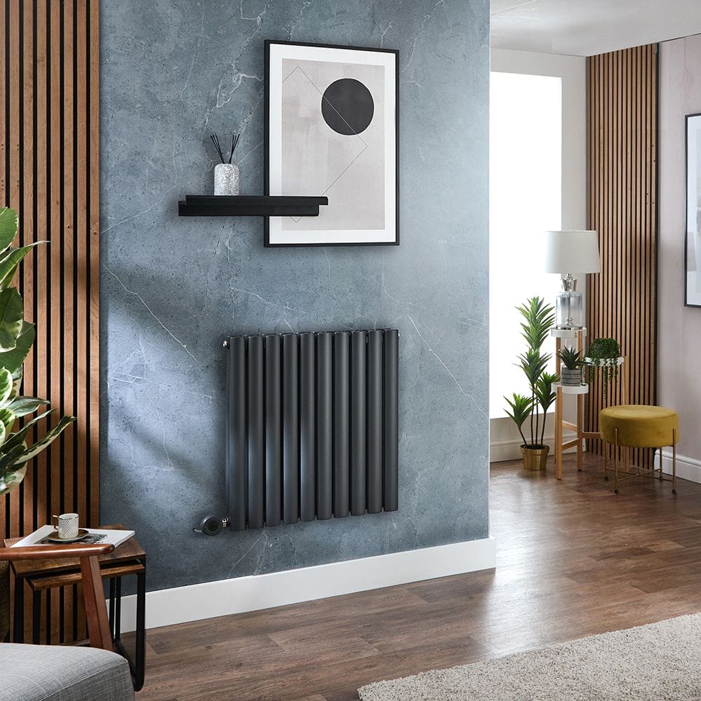 Milano x ECOSO electric antrhactie horizontal designer radiator on light blue wall in modern setting beneath framed artwork