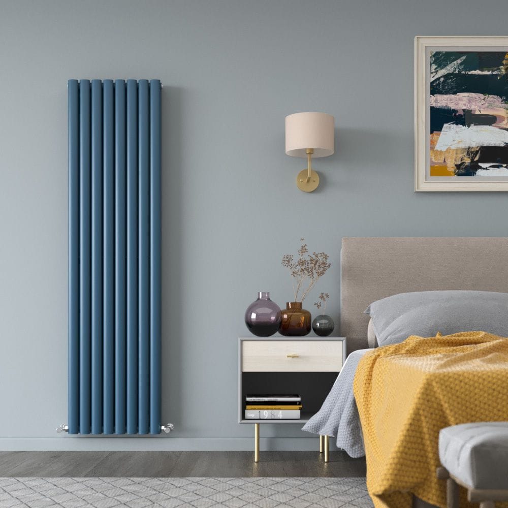Milano Aruba deep sea blue vertical designer radiator on light blue wall nearby bedside table beneath lamp and artwork above bed