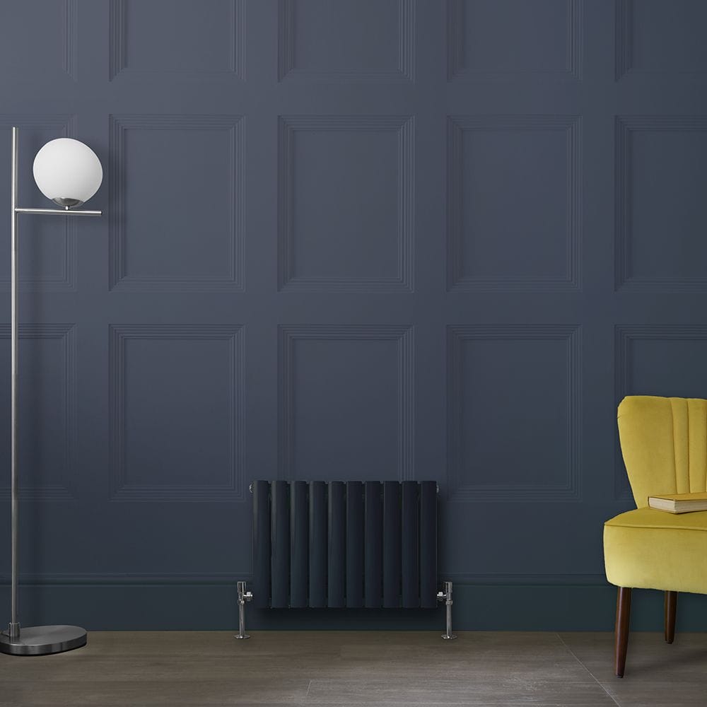 Milano Aruba black horizontal designer radiator on dark blue wall nearby yellow chair and tall lamp