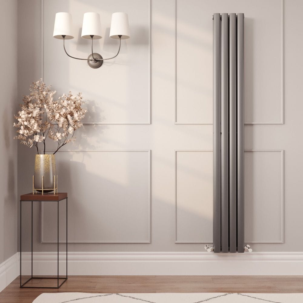 Milano Aruba carbon grey vertical radiator on light wall in modern interior near small table with vase and triple lamp