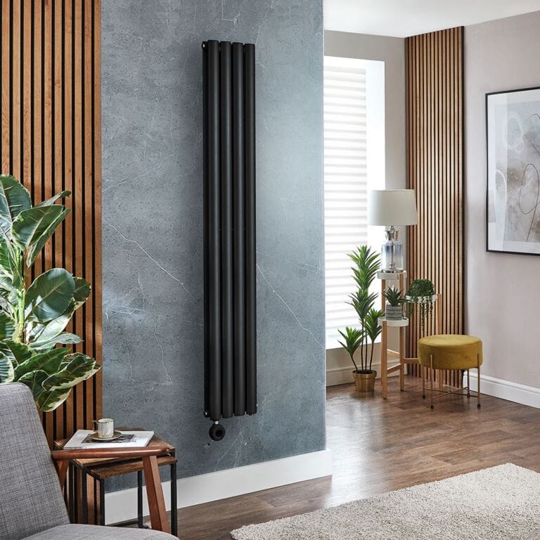 Milano x ECOSO Aruba electric black vertical designer radiator on blue/grey background in modern interior with multiple houseplants and bamboo panelling