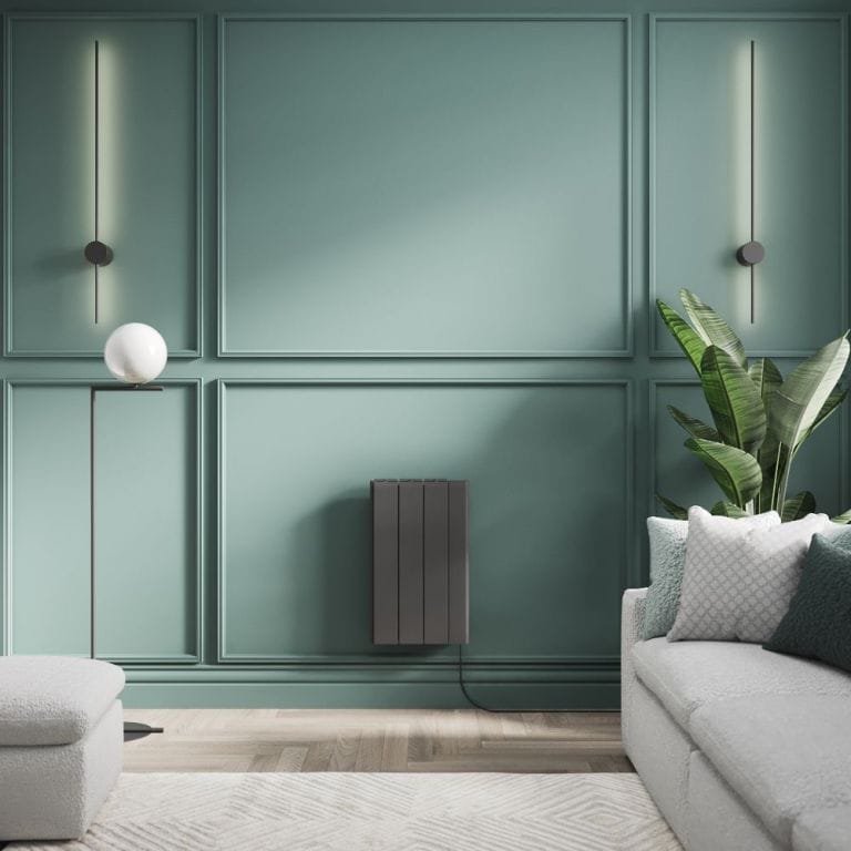 ECOSO Tuc graphite ceramic core smart electric heater on green wall nearby houseplant by light grey settee