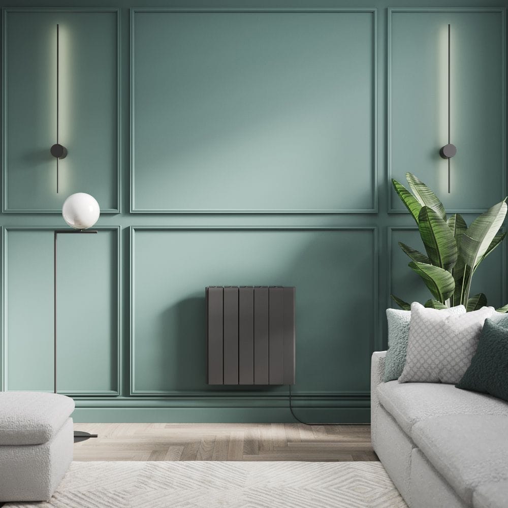 ECOSO Tuc graphite ceramic core plug in smart electric heater on green wall nearby plant and grey settee