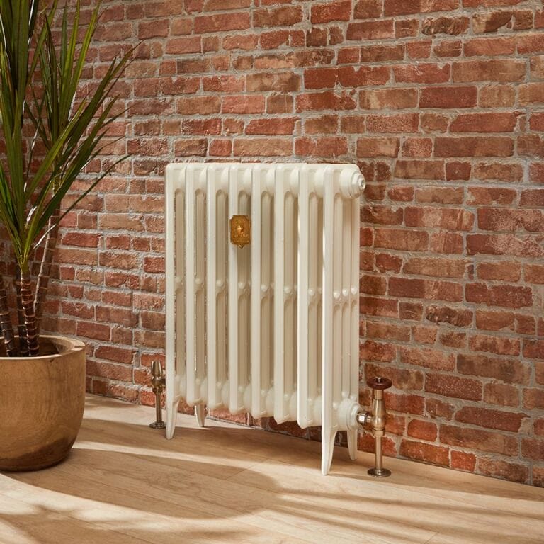 Milano Alice white classic cast iron column radiator on light wooden flooring in front of brick-effect wall