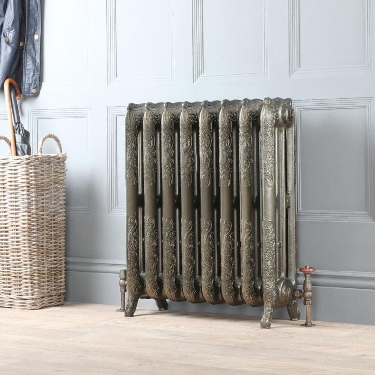 Milano Beatrix antique brass ornate cast iron radiator on light wall nearby basket