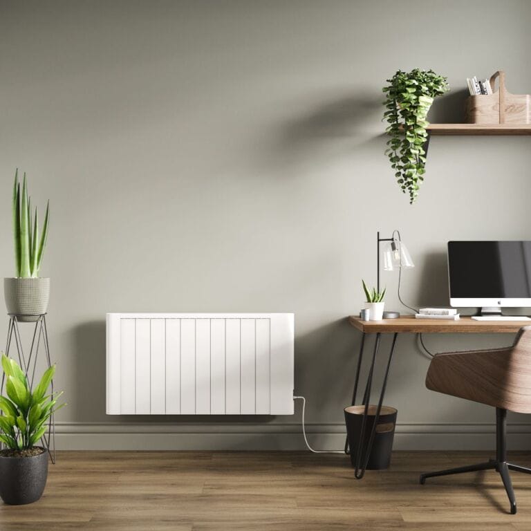 Milano Torr white dry heat plug in smart electric heater on sage green wall in home office nearby houseplants and desk with brown chair and computer