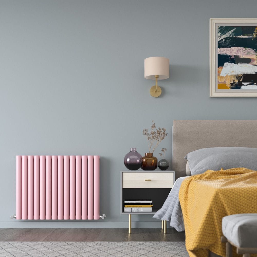 Milano Aruba camellia pink horizontal double panel designer radiator on light blue wall in modern bedroom nearby bedside table with modern vases beneath light fitting and bed beneath artwork