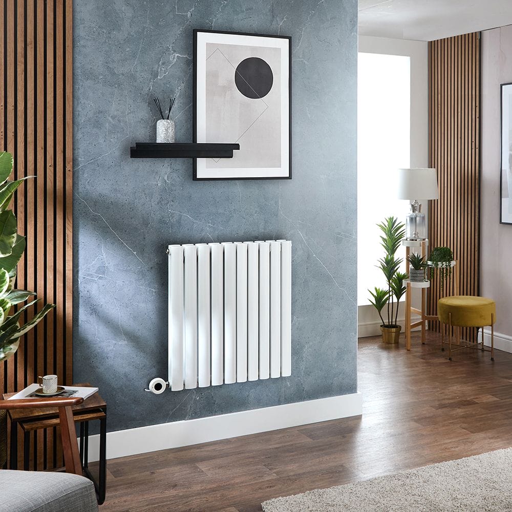 Milano x ECOSO Aruba electric white horizontal designer radiator on light blue wall beneath artwork nearby wooden panelling in modern setting