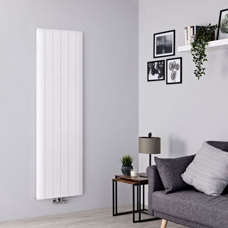 Milano Skye white aluminium vertical designer radiator on light grey wall nearby grey settee under shelf