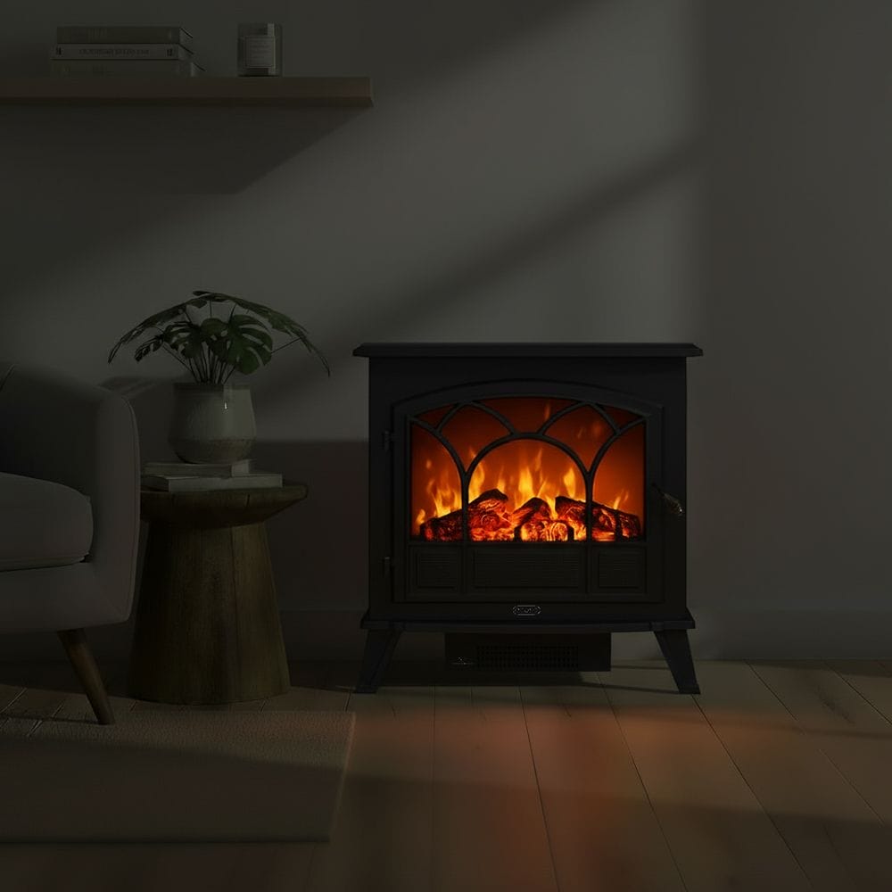 ECOSO Serenity traditional black electric stove in dark room nearby houseplant on small table beneath shelf with books and candle