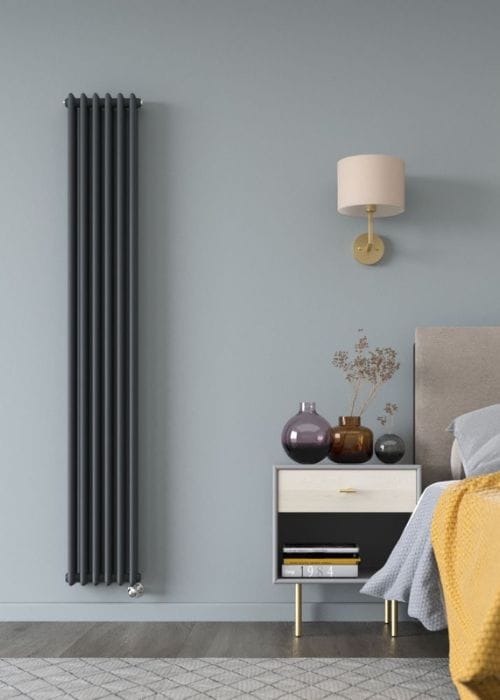 a vertical anthracite milano windsor electric radiator in a blue bedroom