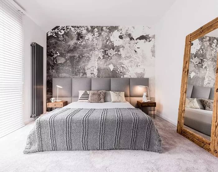 Modern bedroom with metallic silver radiator Modern anthracite bedroom with wall-mounted metallic silver column radiator on one wall and a large mirror on another