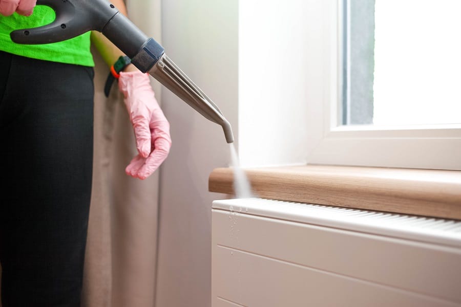 Cleaning professional steam cleaning a white smelly radiator Cleaning professional steam cleaning a white smelly radiator