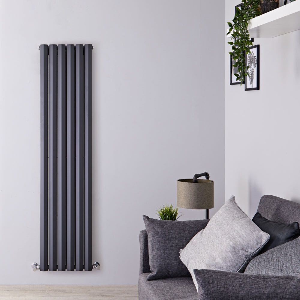 Milano Viti anthracite diamond panel vertical designer radiator on white wall nearby lamp and art covered with plants and grey settee